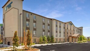A multi-story hotel with a flat facade, multiple windows, and a parking lot in front.