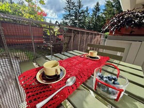 An outdoor dining area with a table set for two, a red tablecloth, and a basket of blueberries. - Ski-In/Ski-Out Flat w/ Balcony, Parking, Wi-Fi (Marilleva 1400)