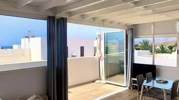Un apartamento moderno con balcón, comedor y sofá.