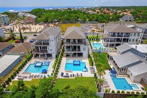 A residential area with multiple two-story houses, each featuring a swimming pool and a covered patio area. - Walk to Beach + Pool, Hot Tub & Game Room 30A Ohana Grande by Avantstay (Santa Rosa Beach)