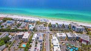 An aerial view of a coastal area with a beach, buildings, and a parking lot. - Walk to Beach + Pool, Hot Tub & Game Room 30A Ohana Grande by Avantstay (Santa Rosa Beach)