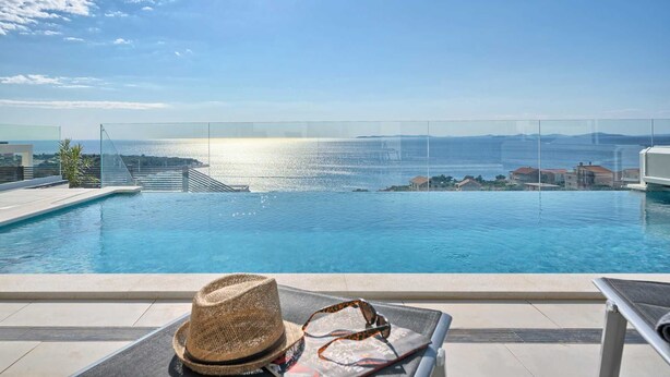 Una piscina con vistas al mar y edificios a la distancia.