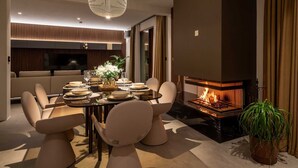 A modern living room with a dining area, a fireplace, and a large chandelier. - Villa Bacci di Sole with Pool (Rogoznica)