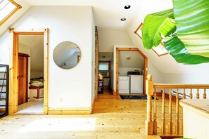 A spacious loft with wooden floors, a kitchen area, and a large mirror. - Short North & Downtown & OSU | Near High Street | Free Parking | 5,800+ Reviews (Columbus)