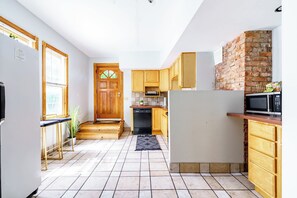 Una cocina compacta con armarios de madera, microondas integrado y lavavajillas.
