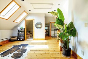 A spacious loft with high ceilings, skylights, a central hallway, and a large potted plant. - Short North & Downtown & OSU | Near High Street | Free Parking | 5,800+ Reviews (Columbus)