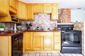 A kitchen with wooden cabinets, a built-in oven, and a backsplash. - Short North & Downtown & OSU | Near High Street | Free Parking | 5,800+ Reviews (Columbus)