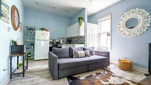 A modern living room with a grey sofa, a cowhide rug, and a kitchen in the background. - Short North & Downtown & OSU | Near High Street | Free Parking | 5,800+ Reviews (Columbus)