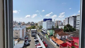 A cityscape with various buildings, a parking lot, and a clear sky. - CONAZ0100 - Edifício Larissa (Salvador)