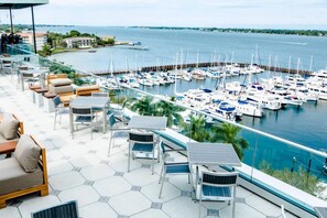 A marina with boats docked, a patio with outdoor seating, and a view of the water.