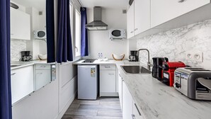 A compact kitchen with a refrigerator, microwave, sink, and a coffee maker.