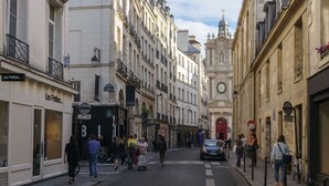 Une rue bordée de boutiques et d’une église.