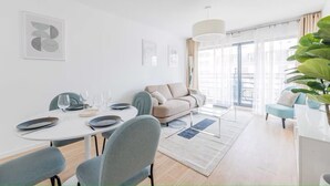 Un salon moderne comprenant un coin repas, un canapé et une grande fenêtre offrant une belle vue.