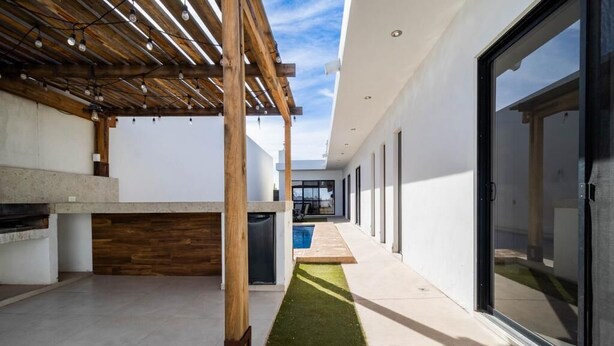 A modern outdoor patio with a wooden pergola, a concrete counter, and a small pool. - Casa Diamante 65 - Spacious residence with private pool in Biznaga, San Carlos, Mexico (guaymas)