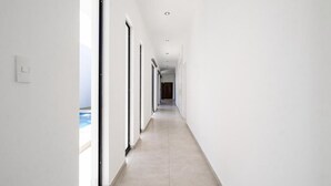 A long, narrow hallway with large windows on one side, leading to a dark doorway at the end. - Casa Diamante 65 - Spacious residence with private pool in Biznaga, San Carlos, Mexico (guaymas)