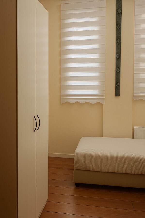 A bedroom with a bed, a wardrobe, and a window with blinds. - Umut Pansiyon Yenikapı (Istanbul)