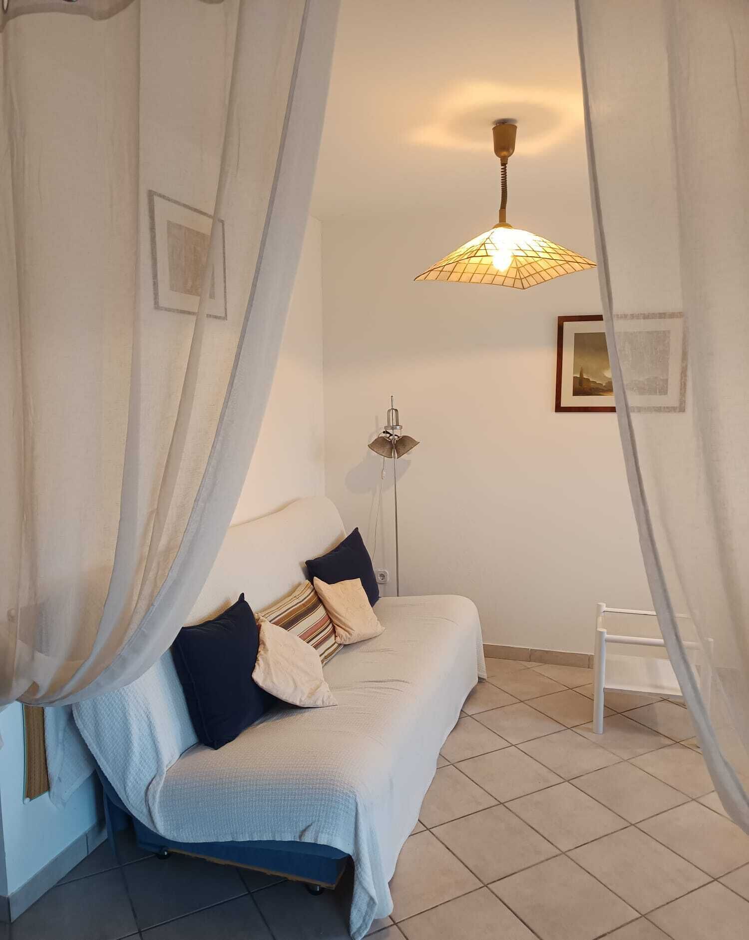 Un dormitorio con cama, lámpara de pie y un cuadro en la pared.