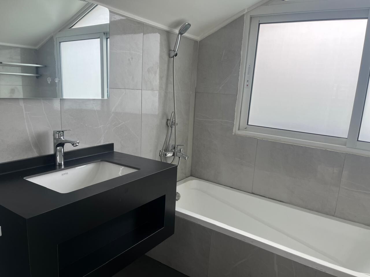 A modern bathroom with a double sink, a shower, and a bathtub.
