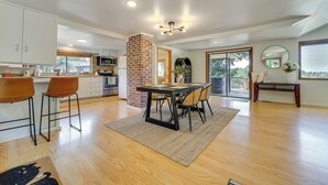 A spacious kitchen with a dining area, featuring a brick column, modern appliances, and a large window. - 1/2 Mi to Yarrow Bay: Family Home in Kirkland (Kirkland)