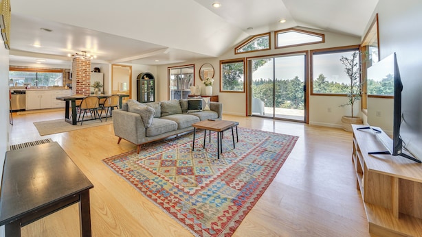 A spacious living room with a large window, a fireplace, and a dining area. - 1/2 Mi to Yarrow Bay: Family Home in Kirkland (Kirkland)
