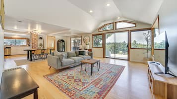 A spacious living room with a large window, a fireplace, and a dining area.