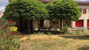 A house with a covered patio, outdoor seating, and a fenced garden area. - L'Escapade, a spacious holiday cottage with a garden near Albi (Albi)