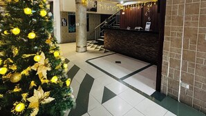A lobby with a Christmas tree, a reception desk, and a staircase. - HOTEL LA CASCADA (Nueva Loja)