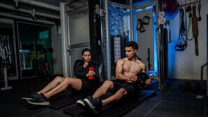 Two people exercising on a mat in a gym with various equipment. - HOTEL LA CASCADA (Nueva Loja)