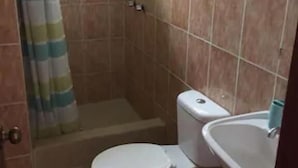 Casa de banho com sanita, lavatório e zona de duche.