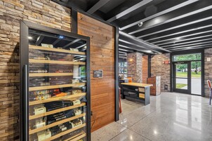 A modern interior with a wine rack, a seating area, and a stone wall.