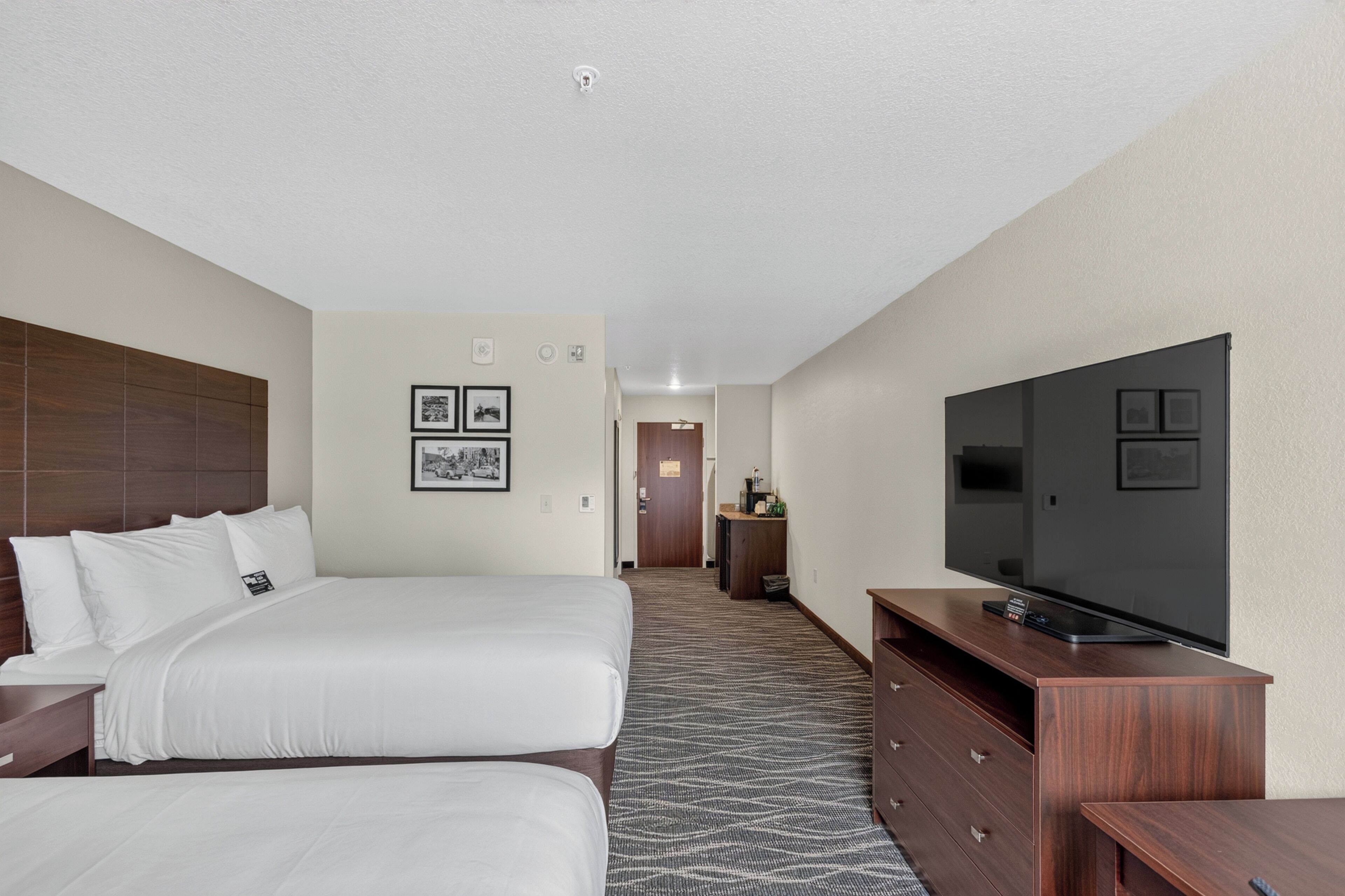 Une chambre d’hôtel avec un lit, une télévision, un bureau et une salle de bain que l’on aperçoit à l’arrière-plan.