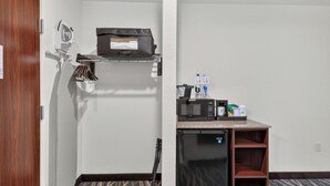 A compact hotel room with a kitchenette, a small refrigerator, a microwave, and a coffee maker. - Cobblestone Hotel & Suites - Waukesha/West Milwaukee (Waukesha)