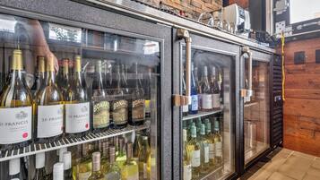 Un espace bar doté d’un réfrigérateur à vin contenant diverses bouteilles.