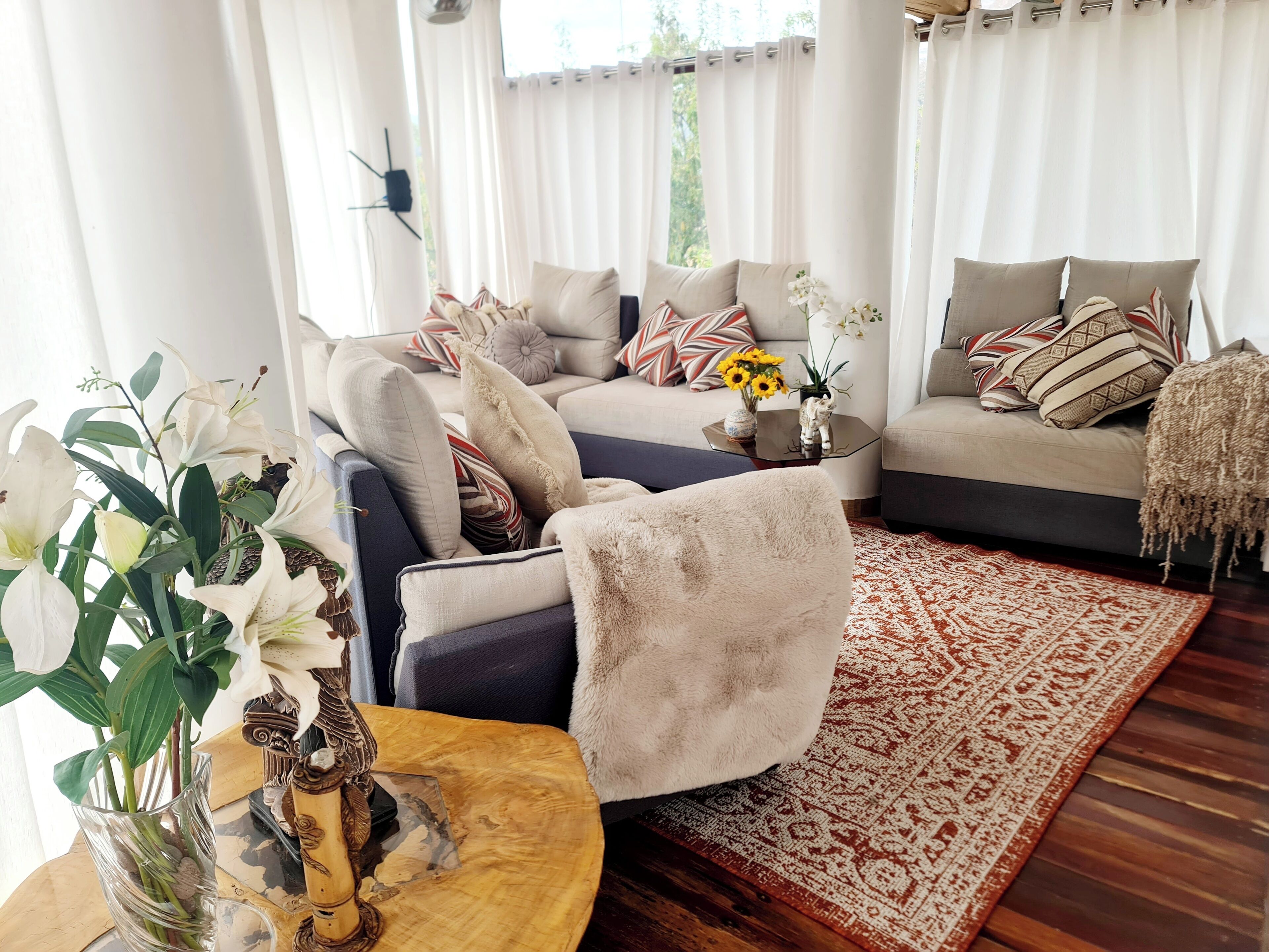 Ein Wohnzimmer mit einer Sofagarnitur, einem Couchtisch und einem gemusterten Teppich.