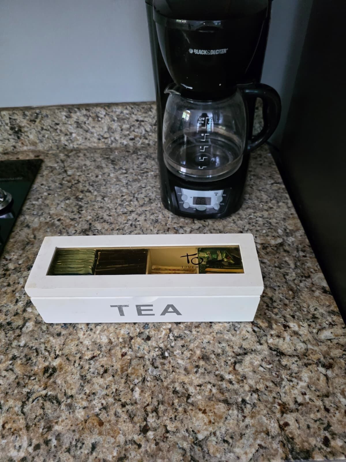 A white box labeled "TEA" on a granite countertop.