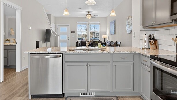 A modern kitchen with a central island, stainless steel appliances, and pendant lighting.