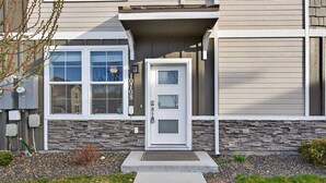 A building with a stone facade, a white door, and a small porch area.
