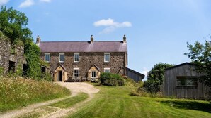 A stone house with a gravel driveway leading to a front door. - Charming Rural Escape with Play Room BBQ (Llawhaden)