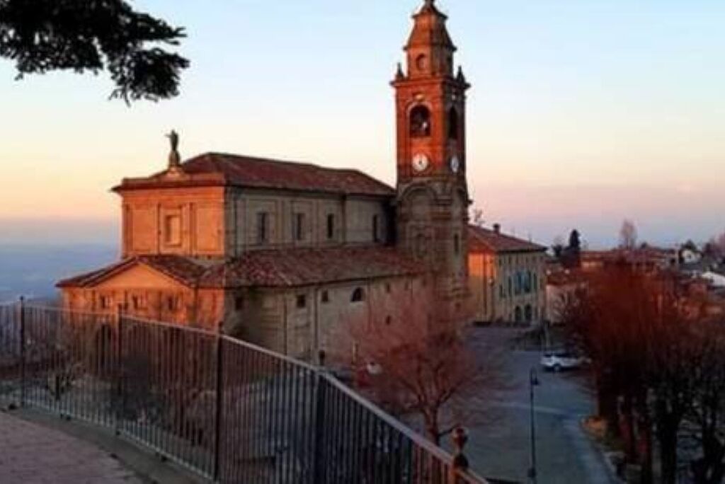 Un edificio histórico con una torre de reloj destacada y un patio amurallado.