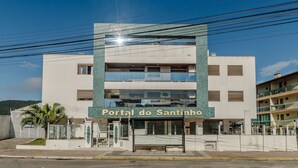 A hotel named "Portal do Santinho" with a modern design, featuring a prominent entrance and multiple floors.