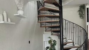 Un salon avec un escalier menant à l’étage supérieur.