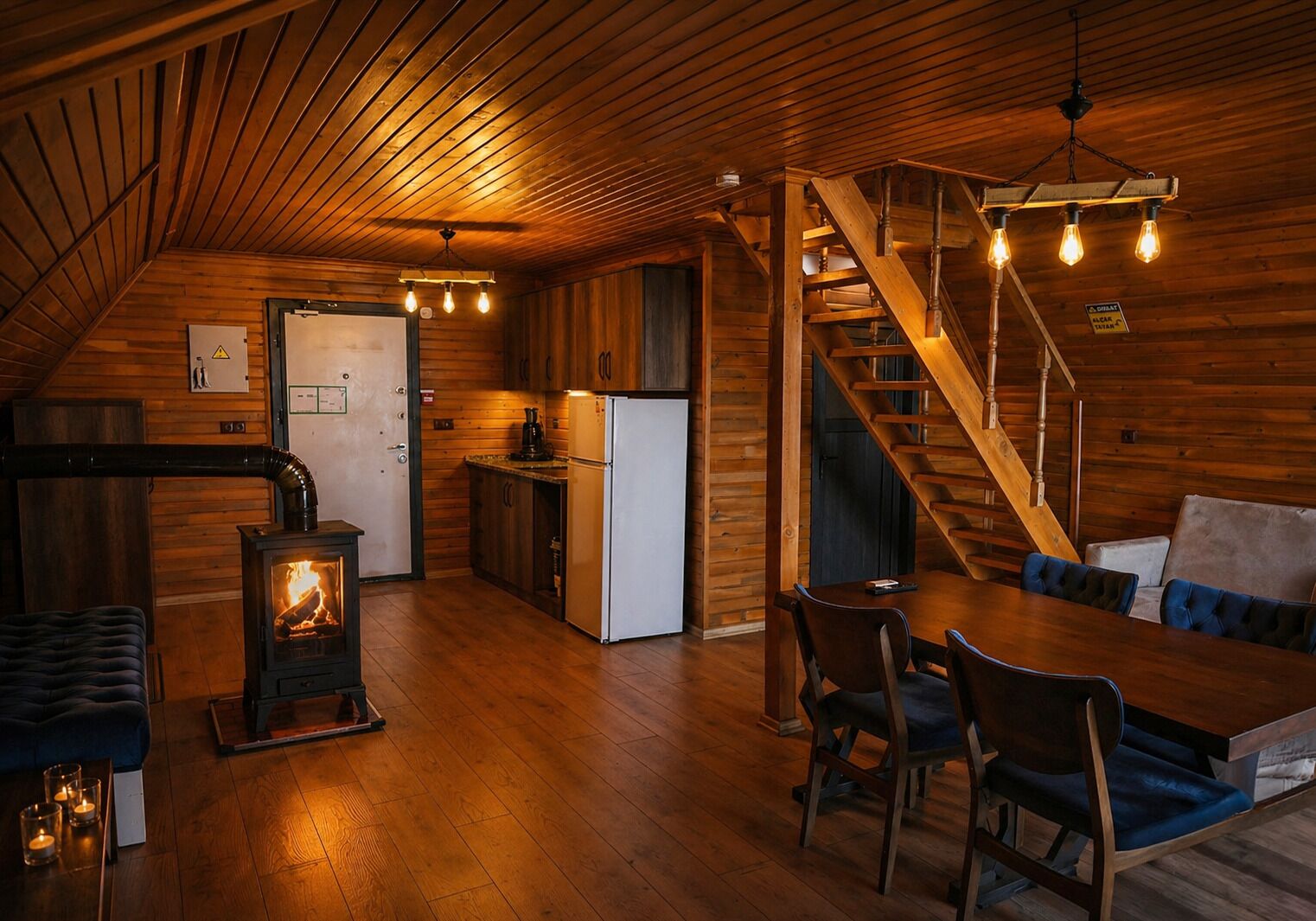 Un acogedor interior de cabaña con detalles de madera, un comedor, una cocina y una escalera.
