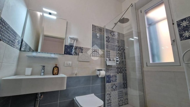A bathroom with a sink, toilet, and shower area. - Polignano Dreams studio apartment (POLIGNANO A MARE)