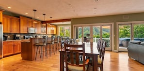 A spacious kitchen with wooden cabinets, a central island, and bar stools.