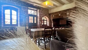 Un comedor rústico con paredes de piedra, una mesa de madera y sillas.