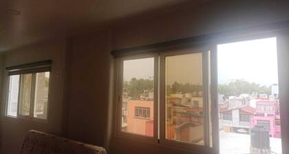 Room with a bed, sofa bed, kitchenette and bathroom.