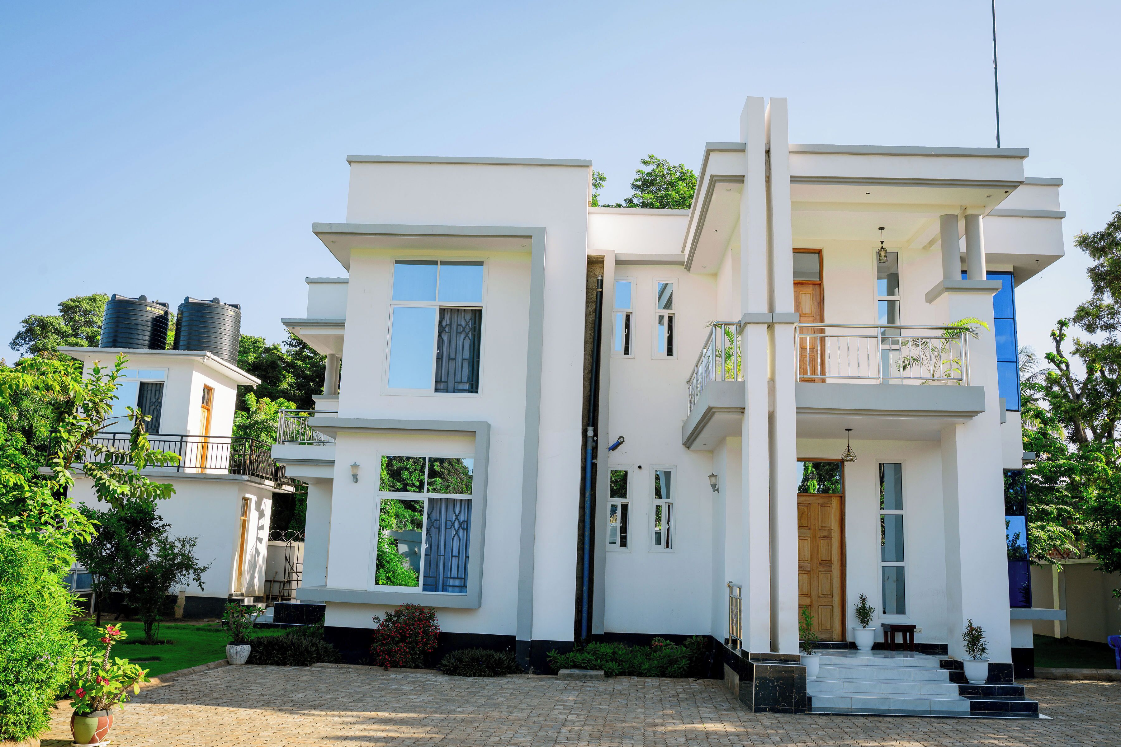 Un bâtiment moderne à deux étages, doté d’un balcon, d’une porte d’entrée et d’un petit espace porche.