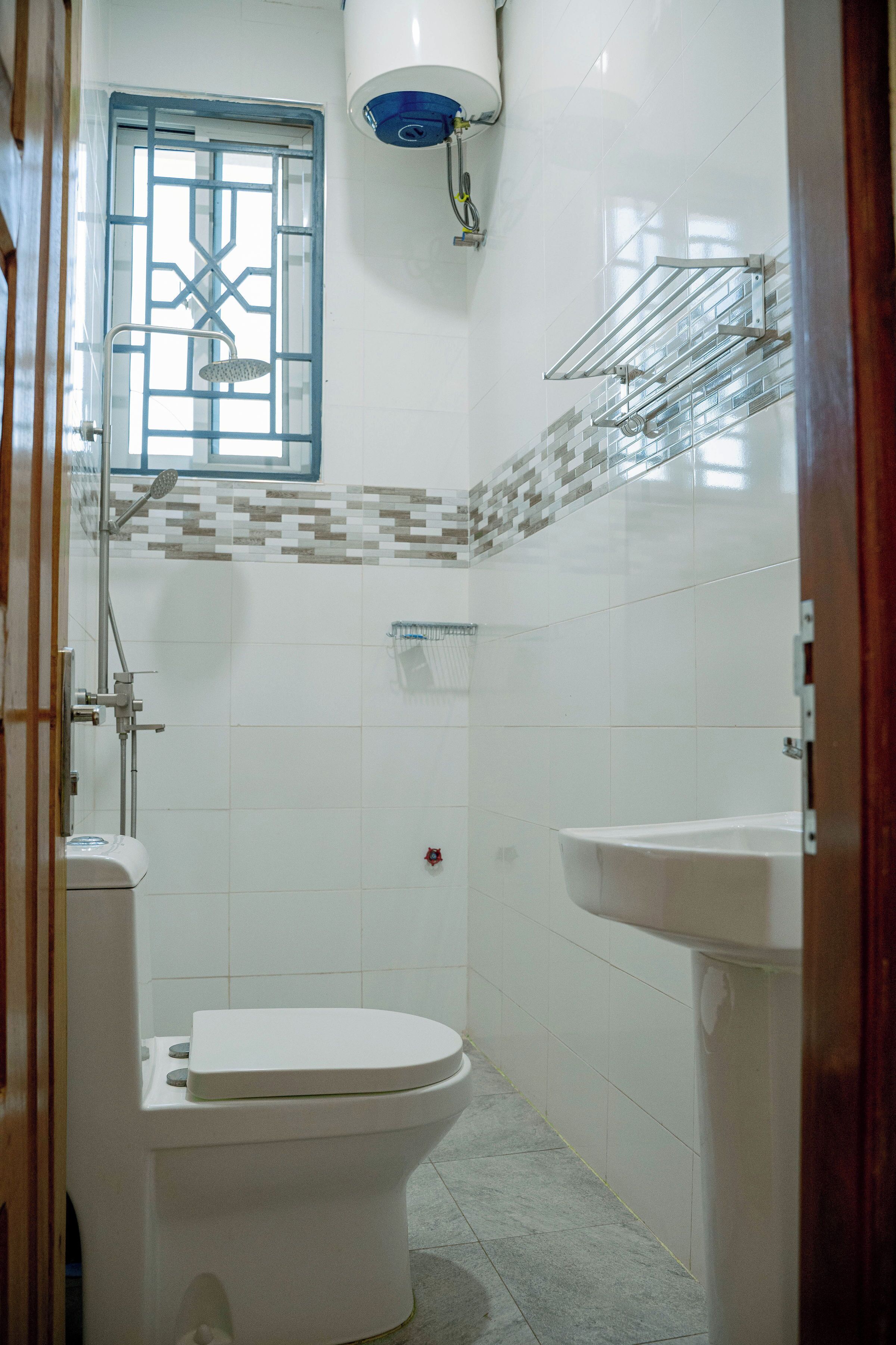 Een badkamer met toilet, douche en wastafel.