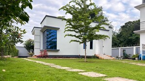 Une maison moderne avec une pelouse bien entretenue et un chemin pavé menant à l’entrée.