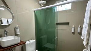 A bathroom with a toilet, sink, and shower area. - Pousada Terras Verdes (Fernando de Noronha)